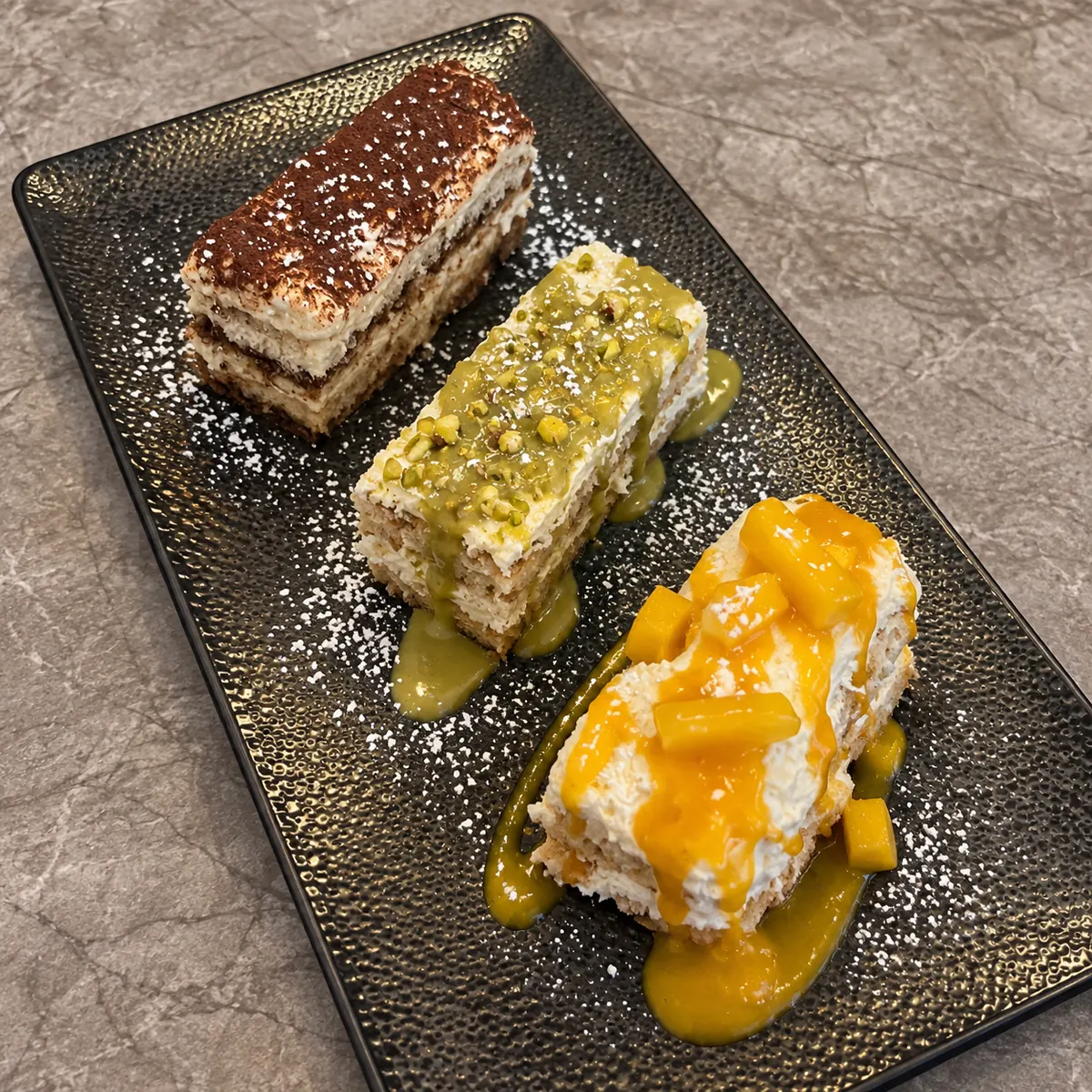 Trio de tiramisus classique, pistache et mangue servi chez La Squadra à Paris 17e